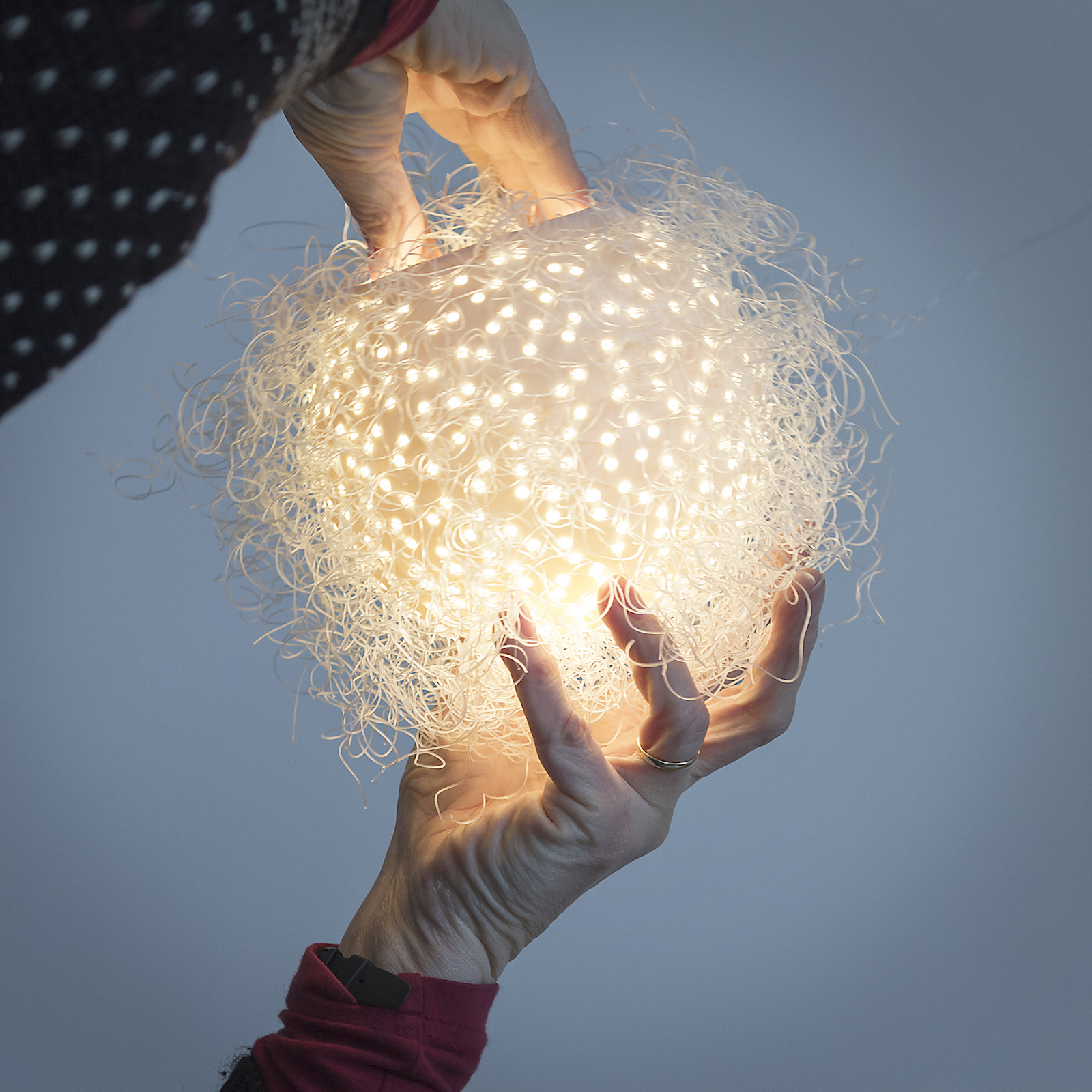 Hands holding porcelain globe pendant