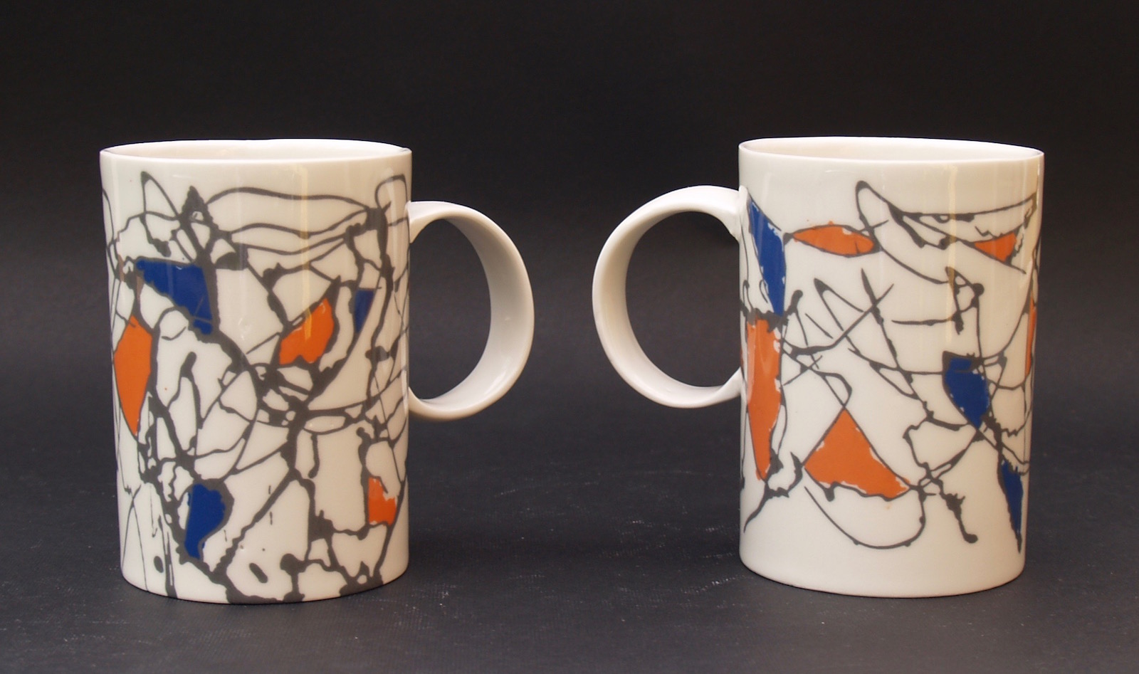 Large porcelain mugs with abstract pattern in black, orange and blue