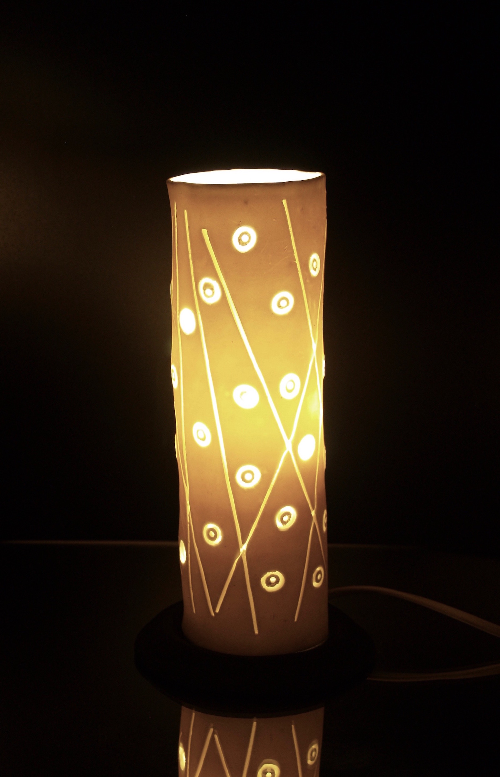 Cylinder shaped table lamp with abstract pattern of dots and lines