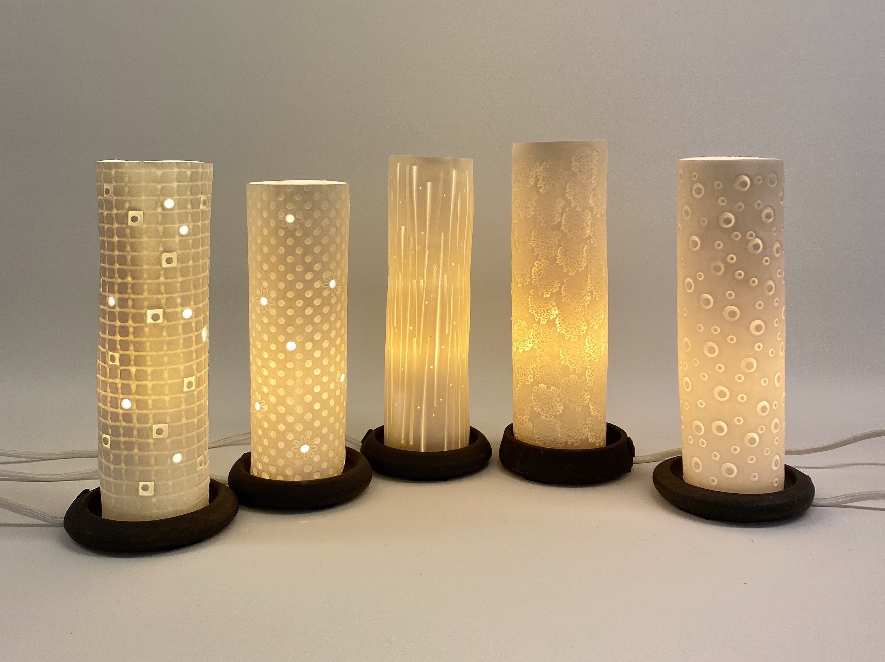 Five cylinder shaped table lamps with abstract patterns